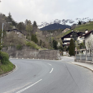 a curve in the road with houses on the side